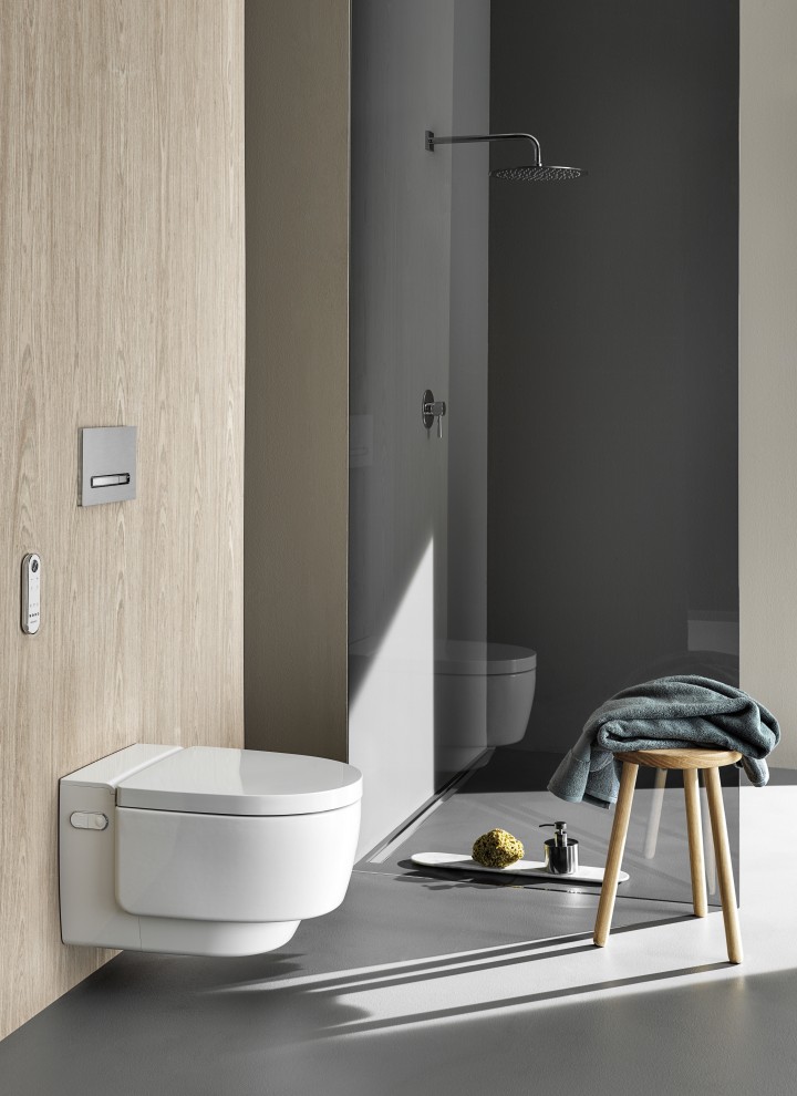 Geberit AquaClean Mera Comfort tuš WC uređaj s daljinskim upravljačem i Sigma50 tipkom za aktiviranje ispiranja (© Geberit)